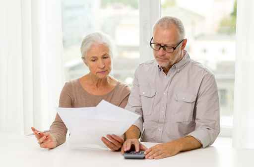 senior couple with papers and calculator at home