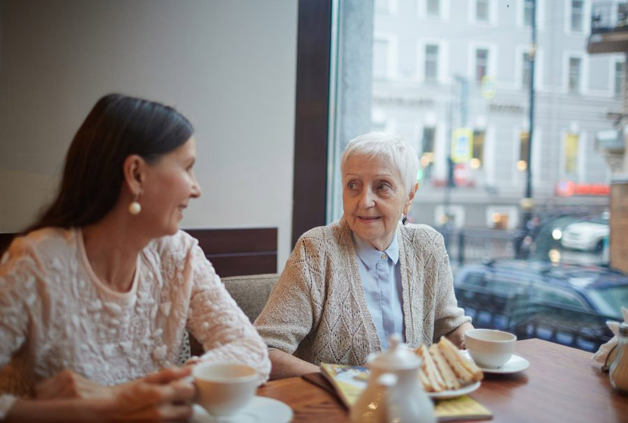 two women sitting at the table having tea